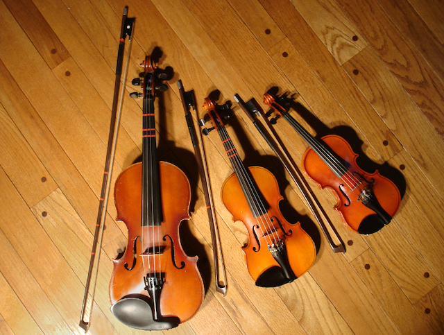 3 Geigen verschiedener Größen mit dem jeweils dazugehörigen Bogen, rote Markierungen für Schüler/innen