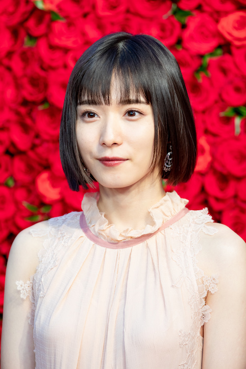 Die Schauspielerin Matsuoka Mayū in einer weißen Bluse mit Rüschenkragen.