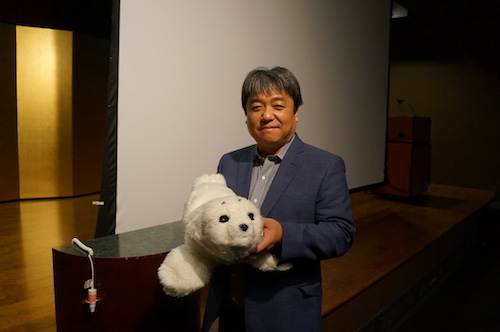 Shibata Takanori hält seine Erfindung, den Roboter-Seehund Paro, auf dem Arm.