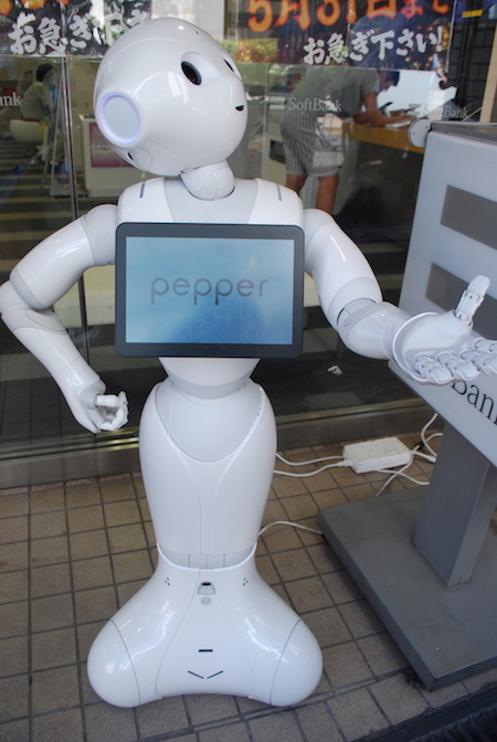 Ein weißer, menschenähnlicher Roboter mit großen schwarzen Augen und einem Bildschirm auf der Brust.