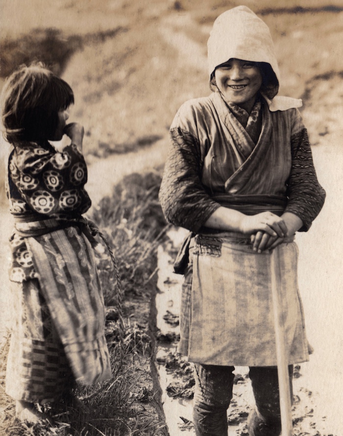 Schwarzweiß-Foto von zwei Mädchen, die ältere mit einem Spaten in der Hand