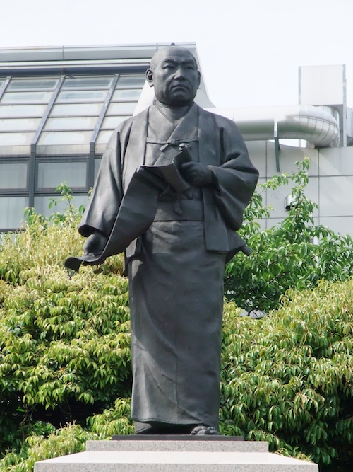 Statue des Ōishi Kuranosuke als Herr mit einer Schriftrolle in den Händen