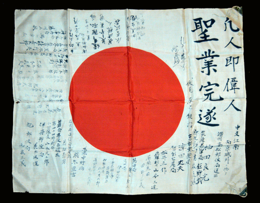 eine japanische Flagge versehen mit Grüßen in schwarzer Schrift