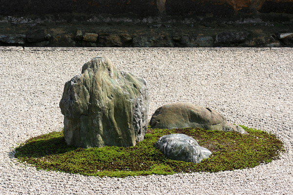 Setzung dreier Steine in einem Kieselbett.