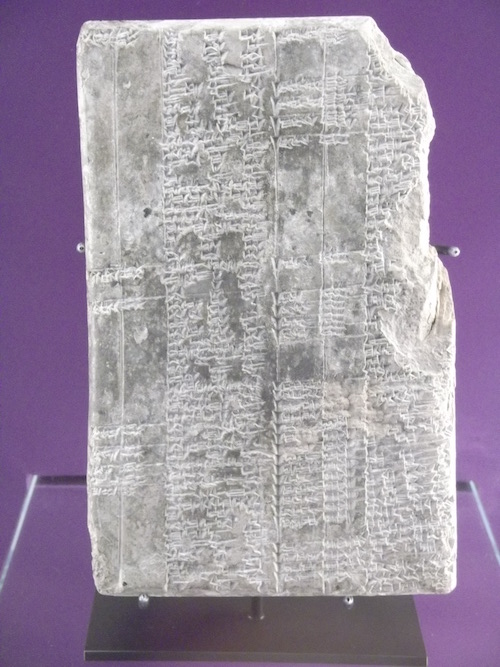 Steinplatte mit systematisch angeordneten Schriftzeichen.