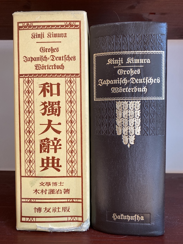 Kinji Kimura, Großes Japanisch-Deutsches Wörterbuch: das Buch in braunem Umschlag neben dem gelblichen Schuber aus Pappe.