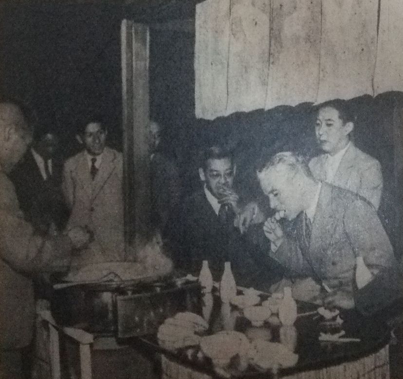 Charles Chaplin bei einem Buffet mit japanischem Essen.