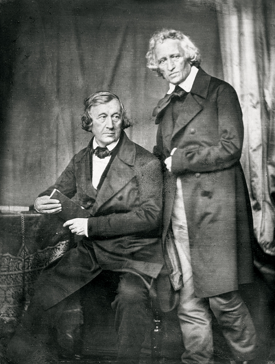 Portraitfoto der Brüder Grimm, der eine sitzend, der andere hinter ihm stehend.