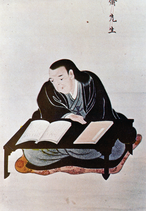 Sitzender Samurai, der sich über seinen Pult beugt und ein Buch studiert.