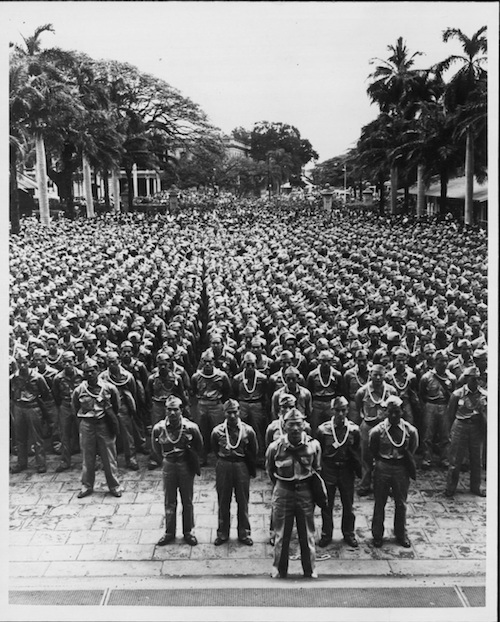 Ein Platz voller japanischstämmiger US-amerikanischer Soldaten, die in Reihen stramm stehen.