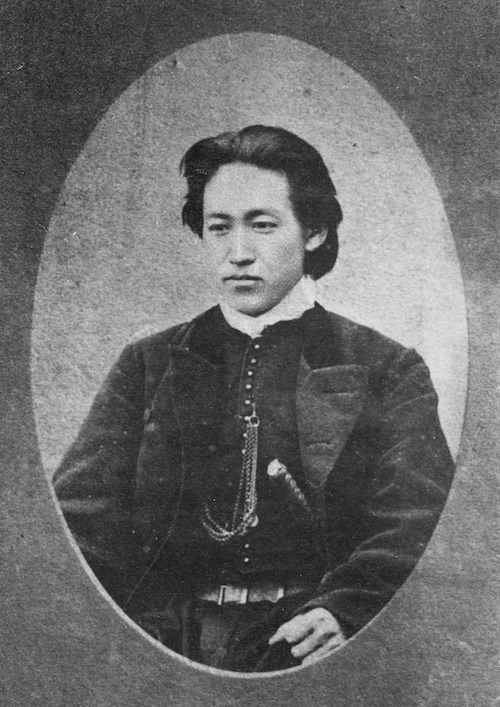 Foto eines jungen Mannes in Anzugsjacke und Schwert an der Seite.