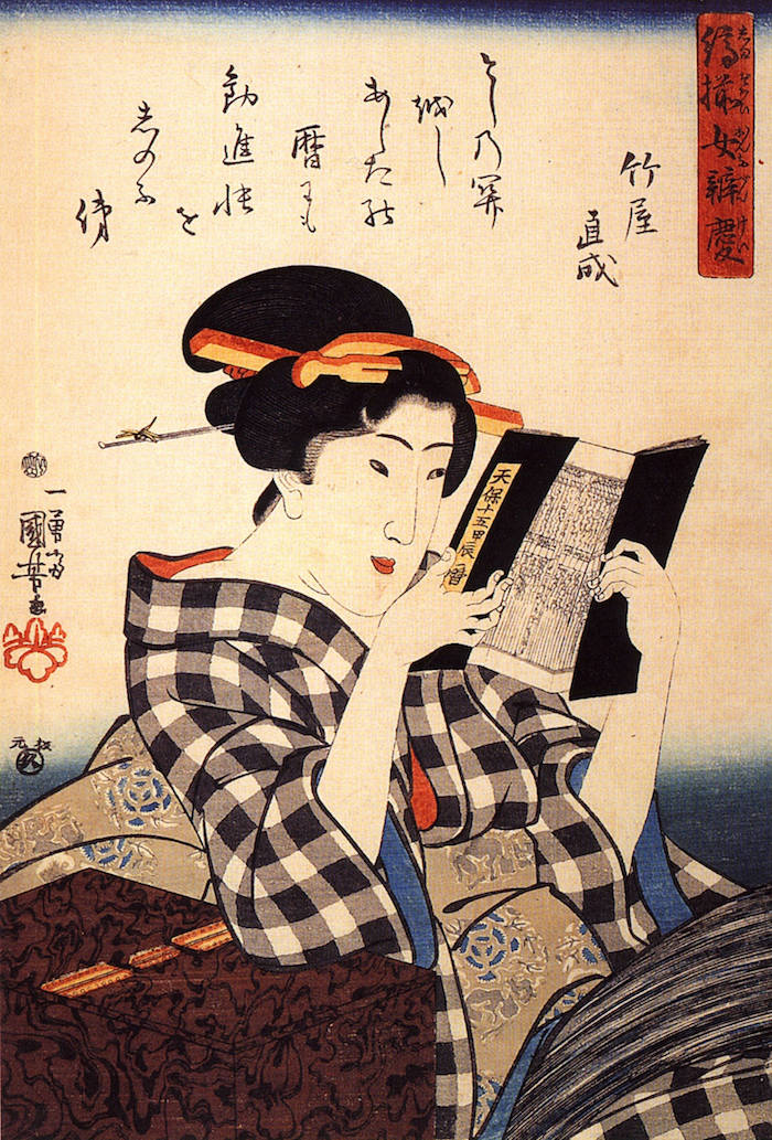 Eine Frau lehnt sich entspannt zurück und liest lächelnd ein Buch.