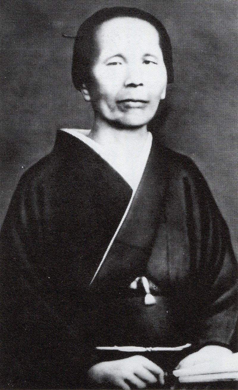 Portraitbild in Schwarzweiß einer älteren Dame in schwarzem Kimono.