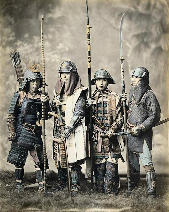 Vier Männer in Samurai-Rüstung, mit Lanzen.