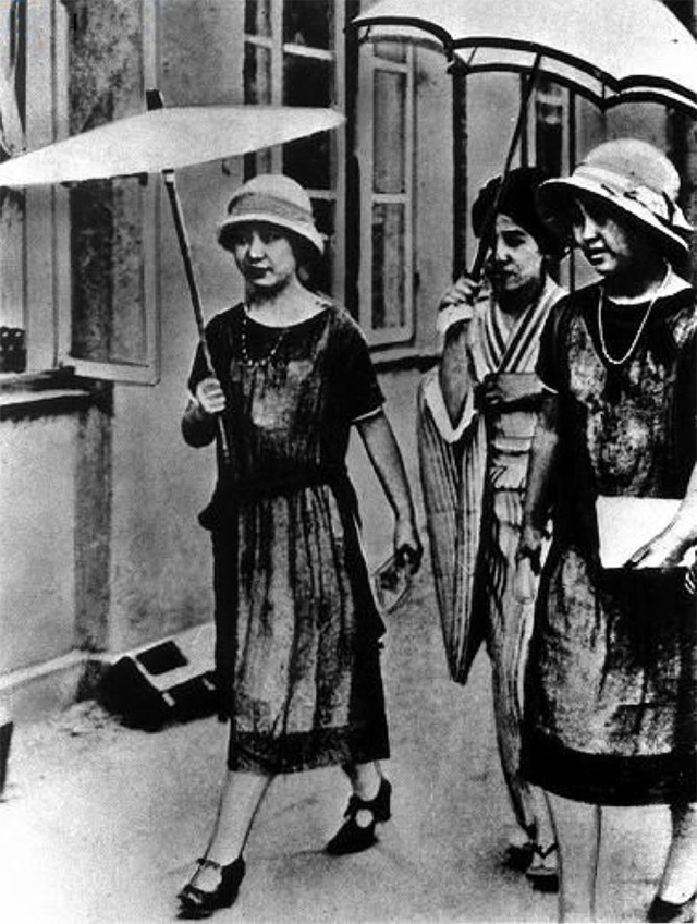 Moga: Schwarzweiß-Foto von drei Damen auf der Straße, 2 von ihnen tragen westliche Kleider und Hüte