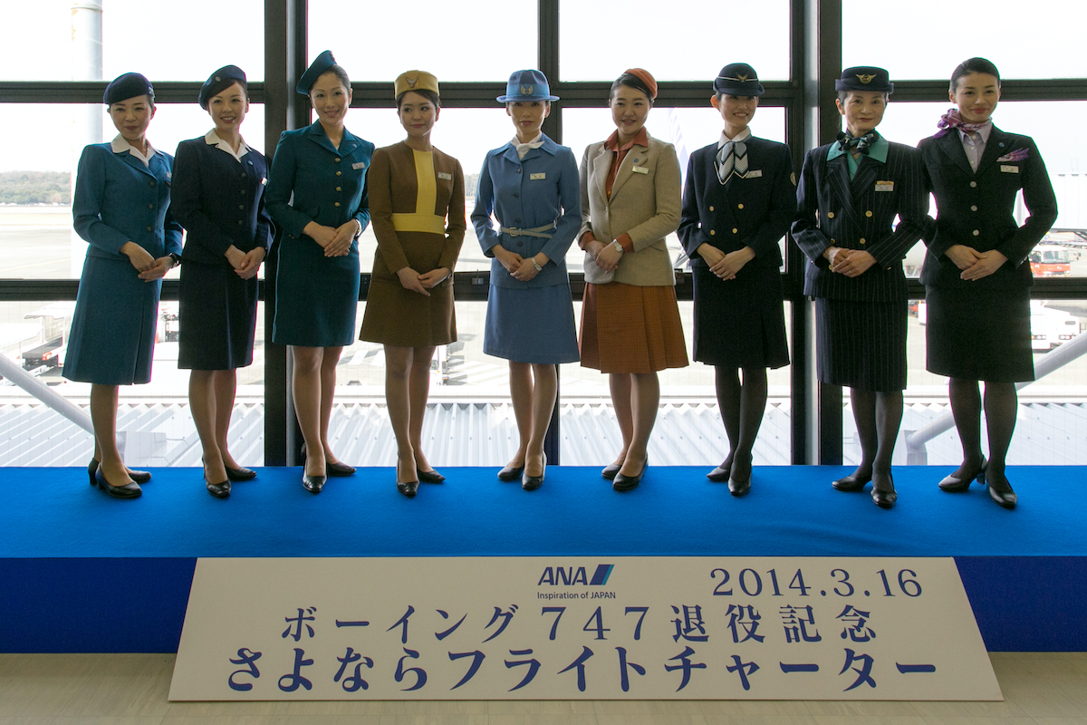 Neun Frauen in verschiedenen historischen Uniformen der Fluglinie ANA